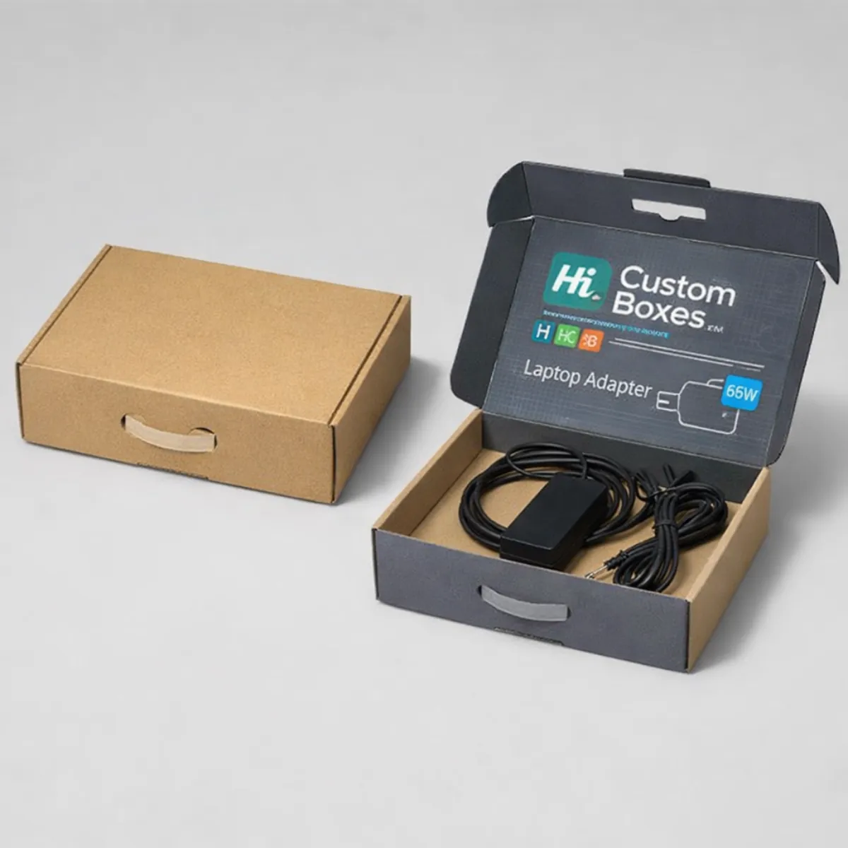 Two brown kraft mailer boxes featuring internal lid printing and a black laptop adapter with coiled cables. class=